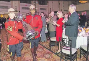  ?? SUBMITTED PHOTO/KEN WALCOTT ?? RCMP officer Ken Walcott, middle, helps escort the Grey Cup during the Canadian Football League commission­er’s brunch at the Fairmont Royal York in Toronto on Nov. 25, 2012. To the right are then Prime Minister Stephen Harper and his wife, Laureen...