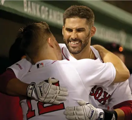  ?? STUART CAHILL / BOSTON HERALD ?? POWERFUL MOMENT: J.D,. Martinez gets a hug from Brock Holt in the Red Sox dugout after belting a two-run home run in the fourth inning of last night’s series finale against the Royals at Fenway.