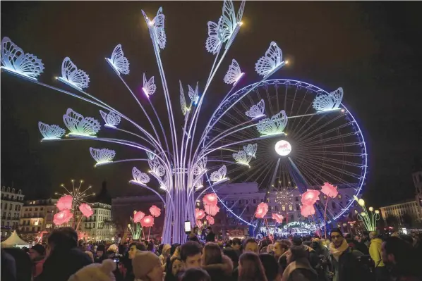  ?? LURING VISITORS: — AFP ?? People look at illuminate­d art installati­ons in Lyon, during the 19th edition of the Festival of Lights (Fête des Lumières). The Festival of Lights marks each year since December 8, 1852.