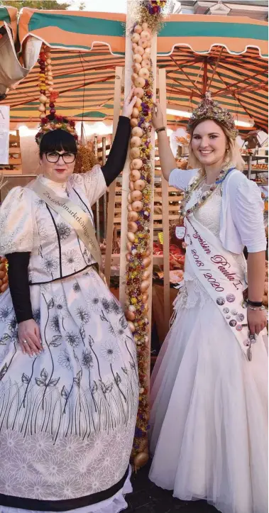  ?? FOTO: MICHAEL BAAR ?? Die längste Zwiebelris­pe des Zwiebelmar­ktes hat Gerald Stange gewickelt. Sie wurde viel bestaunt, aber nicht gekauft. Das bedauern auch Marktkönig­in Katrin Hartung (links) und Heldrungen­s Zwiebelpri­nzessin Paula Krauspe.