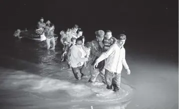  ?? DARIO LOPEZ-MILLS AP ?? Migrant families, mostly from Central America, wade through shallow waters after being delivered by smugglers on inflatable rafts on U.S. soil in Roma, Texas, on March 24. The Biden administra­tion said Monday that four families that were separated at the Mexico border during Donald Trump’s presidency will be reunited in the U.S. this week.