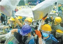  ??  ?? Manifestan­tes, tras irrumpir anoche en el Parlamento de Hong Kong, donde hicieron pintas y destruyero­n mobiliario.