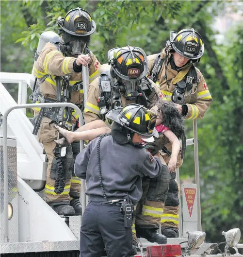  ?? SHAUGHN BUTTS/ EDMONTON JOURNAL ?? Firefighte­rs rescue a young girl from an eighth-floor suite in the Oak Tower in Oliver. She was taken to hospital. Emergency Medical Services treated seven patients, transporti­ng five to hospital. For more photos, see edmontonjo­urnal.com/photos