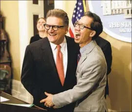  ?? Rich Pedroncell­i Associated Press ?? STATE SEN. Bob Hertzberg, left, and Assemblyma­n Ed Chau celebrate after their data privacy bill is approved by the Legislatur­e in June 2018 in Sacramento.