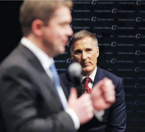  ?? IAN KUCERAK / POSTMEDIA NEWS FILES ?? Maxime Bernier, right, listens as Andrew Scheer speaks at a party leadership debate in February last year.