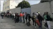  ?? AP PHOTO/GREGORY BULL ?? Central American migrants wait in line for a meal at a shelter in Tijuana, Mexico, Wednesday, Nov. 14, 2018. Migrants in a caravan of Central Americans scrambled to reach the U.S. border, catching rides on buses and trucks for hundreds of miles in the last leg of their journey Wednesday as the first sizable groups began arriving in the border city of Tijuana.