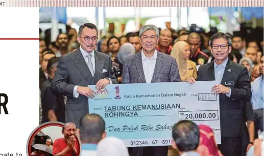  ?? PIC BY ASYRAF HAMZAH ?? Deputy Prime Minister Datuk Seri Dr Ahmad Zahid Hamidi presenting a mock cheque for RM20,000 to Media Prima Bhd group chairman Tan Sri Ismee Ismail (left) at the Police Training Centre in Kuala Lumpur yesterday. With them is Home Ministry...