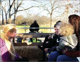  ?? MEGAN DAVIS MCDONALD COUNTY PRESS ?? Visitors to the Ozark Valley Christmas Tree Farm in Southwest City take a short hayride, driven by an antique tractor, down to the valley where the evergreen trees grow each year.