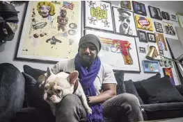  ?? BEBETO MATTHEWS AP ?? Painter Guy Stanley Philoche sits with his dog Picasso at their East Harlem home next to a wall of art collected from other artists.