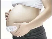  ?? BLOOMLIFE ?? A pregnant woman wears a Bloomlife device, which is designed to track contractio­ns.