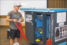  ??  ?? Ian Neumaier, founder of Find Some Flow, arranges items in his rolling locker to prepare for games to be played during a UPMC wheelchair wash and tune up.