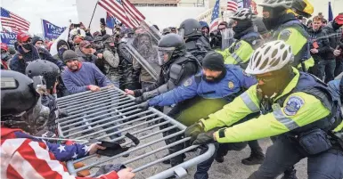  ?? JOHN MINCHILLO/AP ?? Supporters of President Donald Trump try to break through a police barrier on Jan. 6, 2021, at the U.S. Capitol.