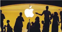  ?? — Reuters ?? Customers walk past an Apple logo inside of an Apple store at Grand Central Station in New York.