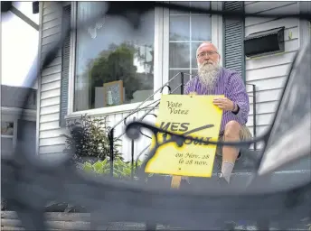  ?? NATHAN ROCHFORD ?? Leo Cheverie poses for a portrait with his sign from the 2005 referendum in Charlottet­own, P.E.I., on Tuesday.