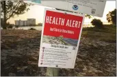  ?? DOUGLAS R. CLIFFORD — TAMPA BAY TIMES VIA AP ?? A sign on Thursday warns visitors to Sand Key Park in Pinellas County, Fla., of the presence of red tide in the surroundin­g waters.