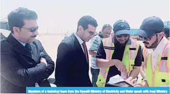  ??  ?? Members of a technical team from the Kuwaiti Ministry of Electricit­y and Water speak with Iraqi Ministry of Water Resources officials at the Kuwaiti-Iraqi border.