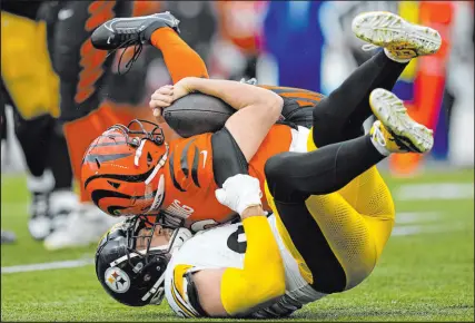  ?? Carolyn Kaster The Associated Press ?? Steelers linebacker T.J. Watt sacks Bengals quarterbac­k Jake Browning in what has become a familiar sight. Watt is one of two players with at least 13 sacks in five of his first seven seasons.