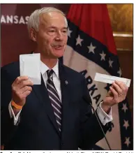  ?? (Arkansas Democrat-Gazette/Thomas Metthe) ?? Gov. Asa Hutchinson displays an Abbott BinaxNOW Rapid Test kit Wednesday during his news conference at the state Capitol in Little Rock. The credit card-size kits can return coronaviru­s test results in about 15 minutes.