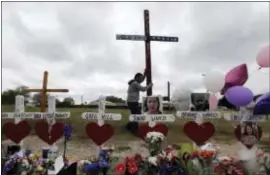  ?? ASSOCIATED PRESS ?? A man stands a cross for the victims of the Sutherland Springs First Baptist Church shooting at a makeshift memorial in Sutherland Springs, Texas. The man who opened fire inside the church in the small South Texas community, killing more than two...