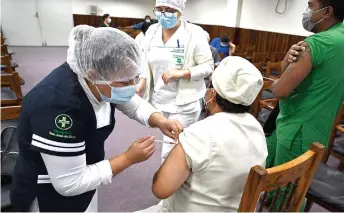  ?? — AFP file photo ?? A health worker is seen injecting her colleague with a dose of the AstraZenec­a/Oxford Covid-19 vaccine in Santa Cruz, Bolivia.