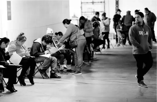  ?? AP ?? In this March 13, 2020 file photo, unionised hospitalit­y workers wait in line in a basement garage to apply for unemployme­nt benefits at the Hospitalit­y Training Academy in Los Angeles.