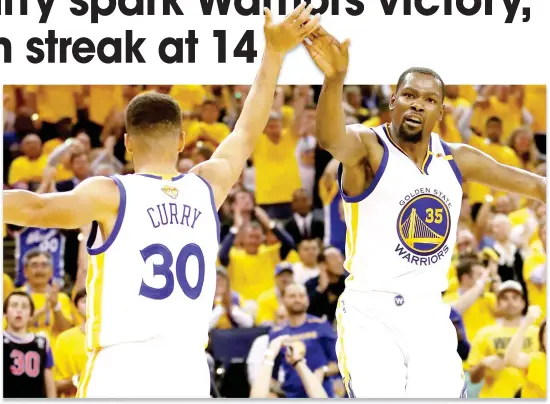  ??  ?? Stephen Curry (30) and Kevin Durant of the Golden State Warriors react to a play against the Cleveland Cavaliers in Game 2 of the 2017 NBA Finals at ORACLE Arena on Sunday in Oakland, California. (AFP)