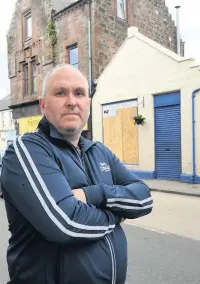  ??  ?? Gutted Davy McKay outside his fire damaged shop on Maybole’s High Street in July