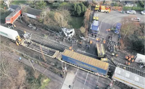  ??  ?? Der Bahnüberga­ng in Düsseldorf-Eller gleicht nach dem Unglück einem Trümmerfel­d. Eine der Lokomotive­n rutschte bei dem Unfall eine Böschung hinab und landete in einer Kleingarte­nsiedlung. Die Zugstrecke bleibt bis Ende des Jahres gesperrt.