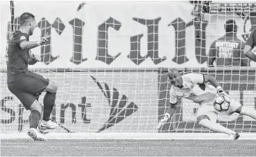  ?? Omar Torres / AFP/Getty Images ?? A penalty kick by Clint Dempsey, left, goes in one direction and Costa Rican goalkeeper Patrick Pemberton moves in the other as the U.S. gets off to a good start with a goal in the ninth minute.