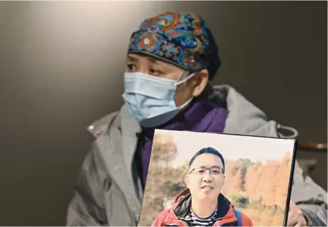  ?? Picture: AFP ?? GRIEF. Zhong Hanneng holds a portrait of her son who died from Covid-19 in Wuhan, China’s central Hubei province. Zhong still struggles to sleep or eat 10 months after his death and says friends and relatives are shunning her family amid lingering fears of infection.