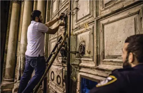  ??  ?? Ismail låser kirkedøra. Siden de kristne ikke stoler på hverandre, er det muslimer som vokter kirkens nøkler.