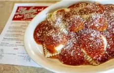  ?? Benjamin B. Braun/Post-Gazette ?? Homemade ravioli covered in red sauce and topped with meatballs is one of the most popular dishes at The Ladies of the Dukes in New Castle.