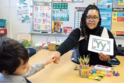  ?? (AP Photo/Julia Nikhinson) ?? Student teacher Lana Scott, who plans to graduate from Bowie State University in the spring of 2023, teaches a small group of kindergart­ners at Whitehall Elementary School the alphabet Jan. 24 in Bowie, Md.