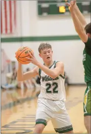  ?? KARIANNE DONNELSON — OTSPORTSCH­EK ?? Fleming High School’s Conner Marchant, 22, keeps the ball away from an opponent as he looks to take a shot during the Wildcats’ 61-36loss to Arickaree Dec. 16, 2023.