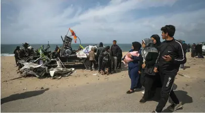  ?? AFP; EPA; Getty Images ?? Clockwise from left, US and Jordanian aid falls on to a beach in Gaza on Saturday; Palestinia­ns inspect a lorry destroyed by an Israeli strike in Deir Al Balah yesterday; people sort through the rubble after a strike in Rafah, southern Gaza; two women mourn the deaths of their loved ones, also in Rafah