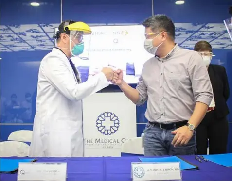  ?? PACT. Dr. Almario Jabson, (Contribute­d photo) ?? President and CEO of TMC Clark (R) in a fist bump gesture with Dr. Ronald Densen, Associate Director of QualiMed during the MOA signing with partner facilities.