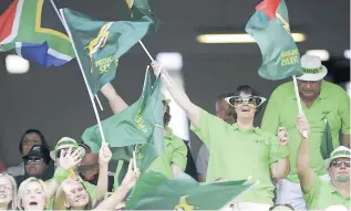  ?? PICTURE: LEON LESTRADE ?? GREEN AND GOLD: Fans celebrate a try at the Cape Town Stadium during the Sevens World Series tournament.