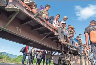  ??  ?? Caravan migrants have been hitching rides on trucks where they can. Mexican authoritie­s have parked buses at checkpoint­s that will return migrants to Central America, but few have taken advantage.