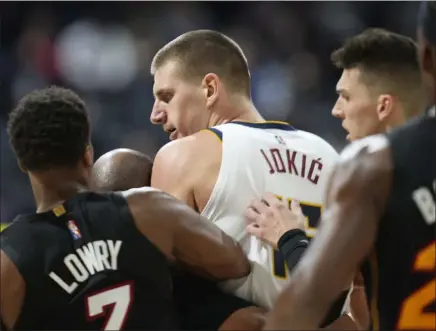 ?? Ap FILE ?? denver nuggets center nikola Jokic, center, is restrained by miami Heat guards Kyle Lowry, left, and Tyler Herro after knocking over Heat forward markieff morris during a scrum last week.