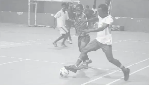  ??  ?? Benjamin Opara (blue) of the African Team attempting to win possession from an Old School Ballers player during their clash at the National Gymnasium in the inaugural Futsal Nation Cup