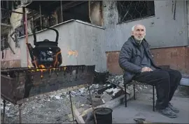  ?? Alexei Alexandrov Associated Press ?? A RESIDENT waits for his kettle to boil in Mariupol, Ukraine. Russia has sought to capture the city, laying siege to a steel factory sheltering Ukrainian defenders.