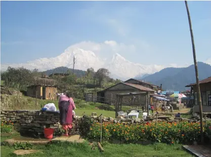  ?? (Brian Blum) ?? MOUNTAINS PROVIDE a stunning backdrop for a Nepalese village.