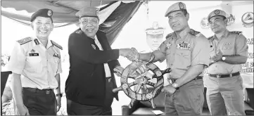  ??  ?? Ahmad Puzi (second left) presents a ship’s steering wheel to Azmy to symbolical­ly mark the handover of the two vessels to APM Miri, witnessed by Ismaili (left) and Moktar.