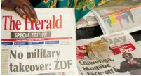  ?? (Philimon Bulaway/Reuters) ?? A VENDOR picks up a copy of a special edition of the stateowned daily newspaper ‘The Herald’ in Harare, Zimbabwe, yesterday.