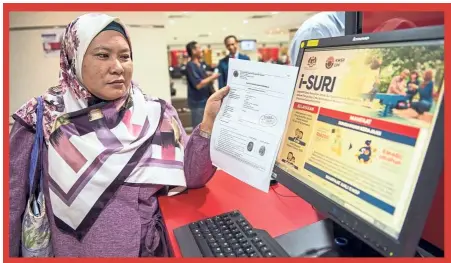  ??  ?? housewife Jamaliah Ismail showing her approved i-suri registrati­on form at the EPF headquarte­rs in Jalan raja Laut, Kuala Lumpur. — Bernama