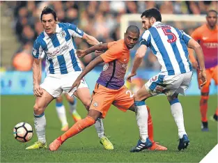  ??  ?? City’s Fernandinh­o finds himself in a Huddersfie­ld Town sandwich.