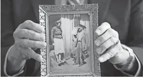  ?? DORAL CHENOWETH PHOTOS/DISPATCH ?? Burgess holds a 1941 photograph of his grandfathe­r, Lewis “Bucktufts” Tufts as he shares Jehovah’s Witness literature.