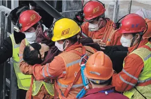  ?? CHEN HAO THE ASSOCIATED PRESS ?? Rescuers carry a miner who was trapped to an ambulance in Qixia City in east China’s Shandong Province, Sunday. Eleven workers trapped for two weeks by an explosion inside a Chinese gold mine were brought safely to the surface on Sunday.