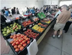  ?? John Lucas/Edmonton Journal ?? The Callingwoo­d Farmers Market’s first mid-week market was marred by an enormous dump of snow, but shoppers were met by the sun as they wandered the stalls on Mother’s Day.