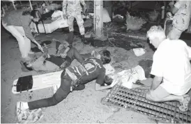  ??  ?? The injured are helped after a bomb blast in the southern resort city of Hua Hin, 240km south of Bangkok, Thailand. Police are investigat­ing a series of bomb blasts in Hua Hin and other cities in Thailand. Daily News